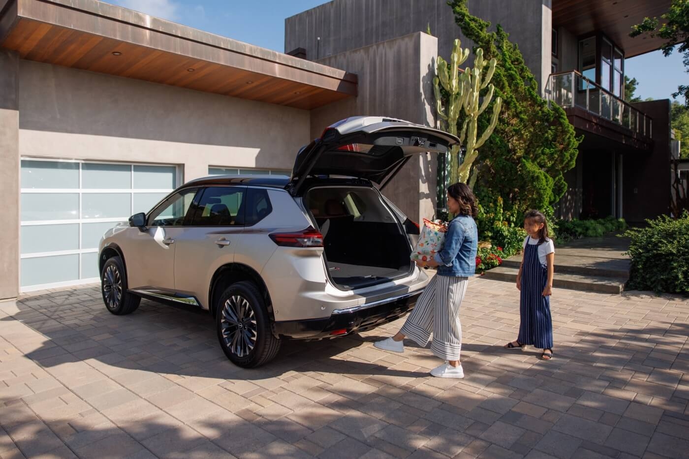 Mère ouvrant le coffre du Nissan Rogue 2024 à la maison.